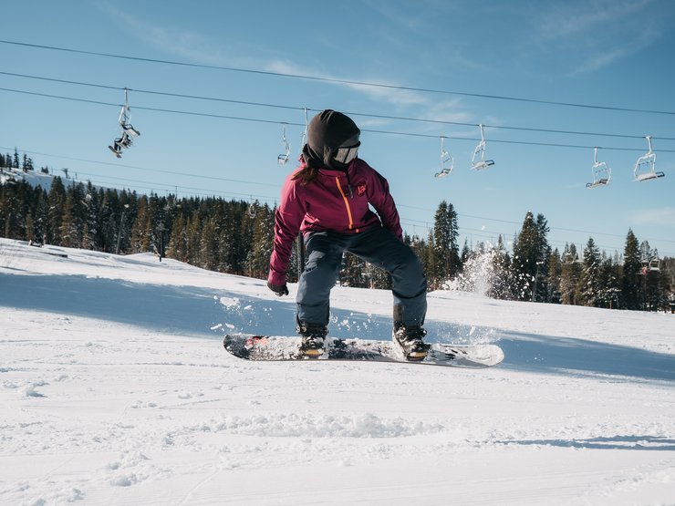 4) Folge dem natürlichen Bogen deines Aufwärtsschwungs. Beide Füße sollten am höchsten Punkt deines Ollies parallel zum Schnee sein, um die Stabilität in der Luft aufrecht zu erhalten.